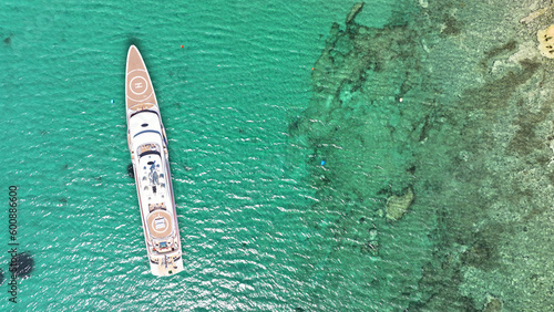 Aerial drone photo of luxury yacht with helipad anchored in tropical exotic island with emerald crystal clear sea © aerial-drone