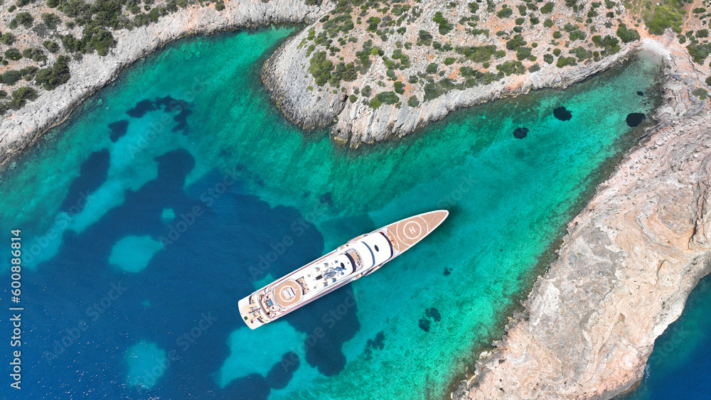 Aerial drone photo of luxury yacht with helipad anchored in tropical exotic island with emerald crystal clear sea
