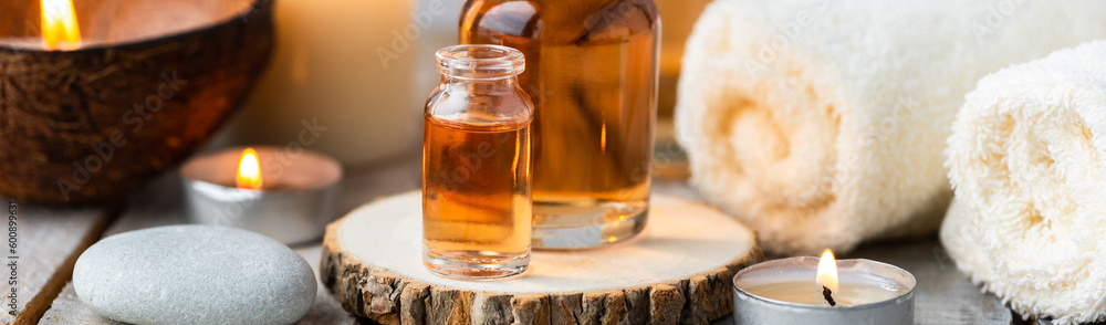 Concept of spa treatment in salon with pure organic natural oil. Atmosphere of relax, detention. Aromatherapy, candles, towel, wooden background. Skin care, body gentle treatment Concept of spa treatment in salon with pure organic natural oil. Atmosphere of relax, detention. Aromatherapy, candles, towel, wooden background. Skin care, body gentle treatment
