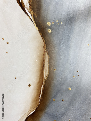 Abstract brown art with gold and gray — beige background with golden paint. Beautiful smudges and stains made with alcohol ink. Brown fluid art texture resembles brown marble, watercolor or aquarelle.