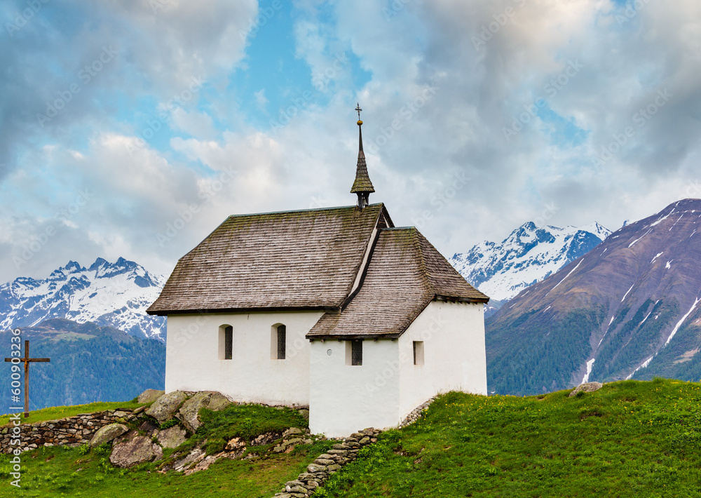 Lovely small old Church in Bettmeralp Alps mountain village, Switzerland. Summer cloudy view.