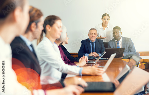 Manager introduces new company executives to colleagues in meeting room