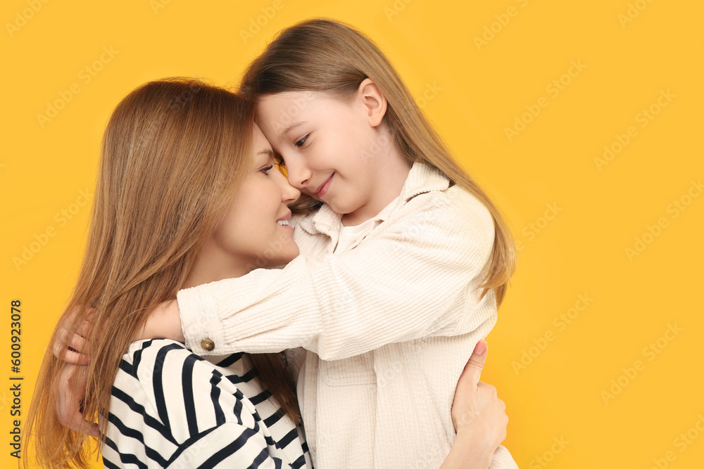 Portrait of happy mother and her cute daughter on orange background Portrait of happy mother and her cute daughter on orange background