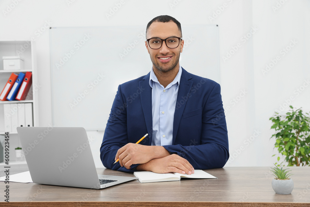 Happy young intern working at table in modern office Happy young intern working at table in modern office