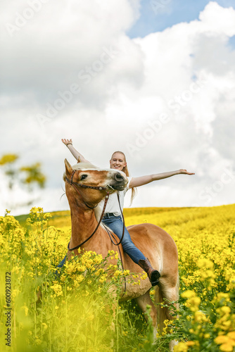 A young woman enjoying time with her haflinger horse in spring outdoors. Female equestrian friendship scene with her horse