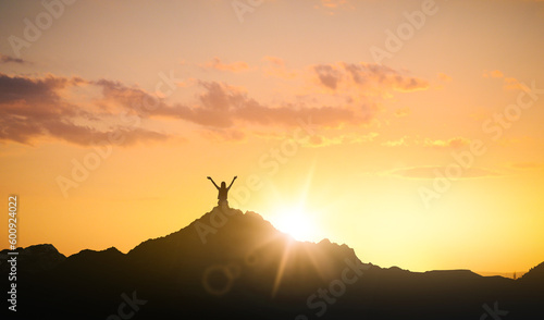 Silhouette of woman in mountains under sky at sunset