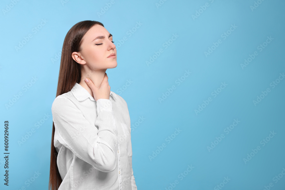 Young woman with sore throat on light blue background. Space for text Young woman with sore throat on light blue background. Space for text