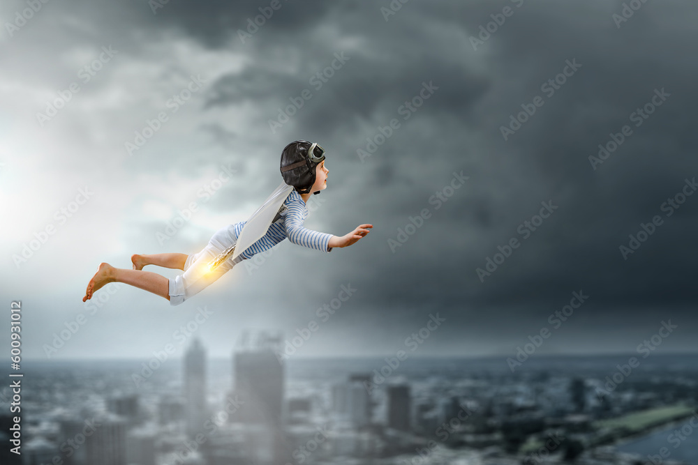 Happy little boy flying wearing helmet Happy little boy flying wearing helmet