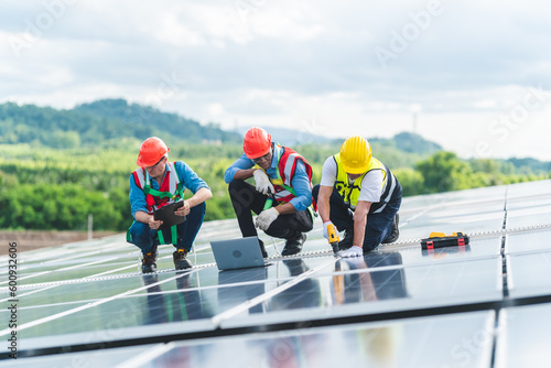 Technician engineer service meeting and checking solar cell on rooftop of industrial factory. Inspection worker repair solar cell panels. Clean Renewable energy, Ecology and alternative power concept © chokniti