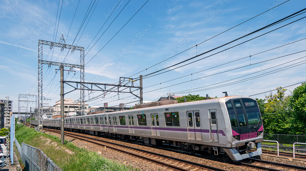 郊外の住宅地を走る通勤電車