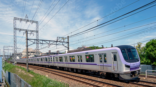 郊外の住宅地を走る通勤電車