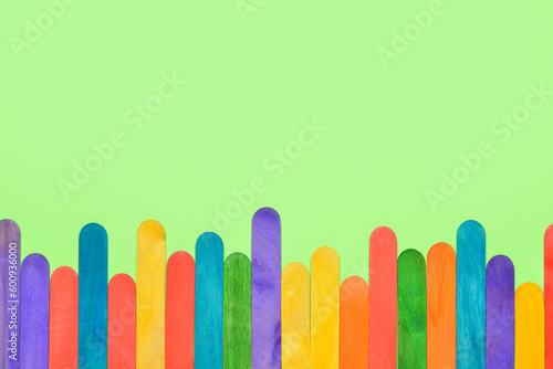 Colorful ice cream sticks on green background