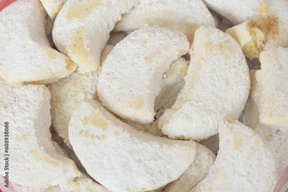 Close up Kue putri salju or princess snow cookies. Is melt in the mouth cookies has a shape of crescent coated in icing sugar and popular indonesian cookies for Eid Mubarak. Close up Kue putri salju or princess snow cookies. Is melt in the mouth cookies has a shape of crescent coated in icing sugar and popular indonesian cookies for Eid Mubarak.