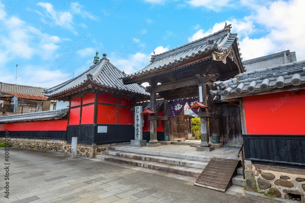 Fototapeta premium Nakatsu, Japan - Nov 26 2022: Goganji Temple (Red Wall Temple) established by daimyo Kuroda Yoshitaka and founded by the priest Kuyo, situated a little south of the center of the Tera-machi district