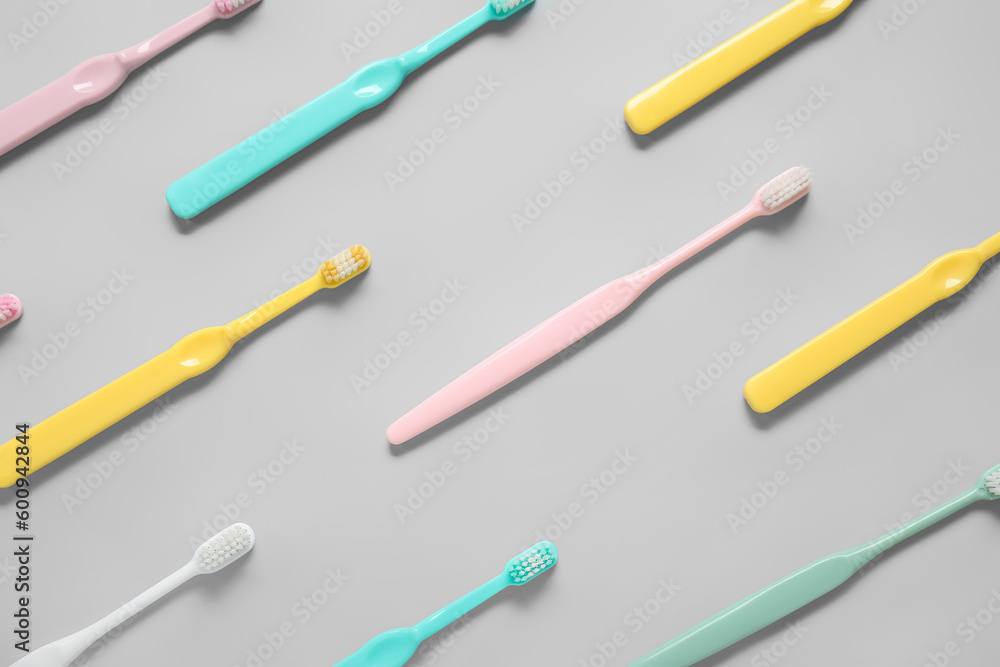 Plastic toothbrushes on grey background Plastic toothbrushes on grey background
