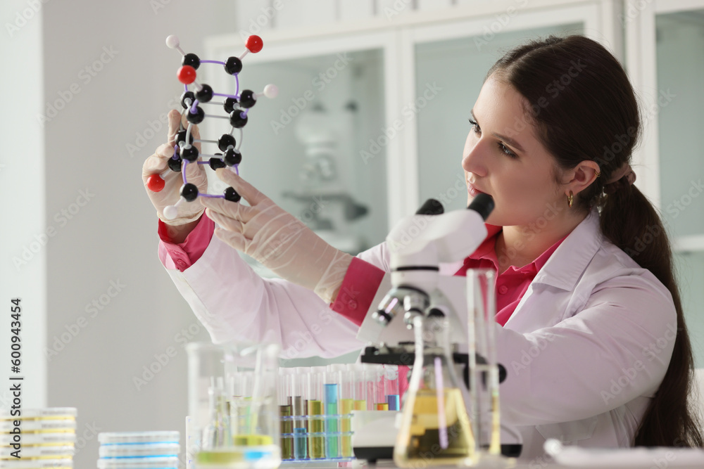 Scientist woman holding model of molecule in laboratory Scientist woman holding model of molecule in laboratory