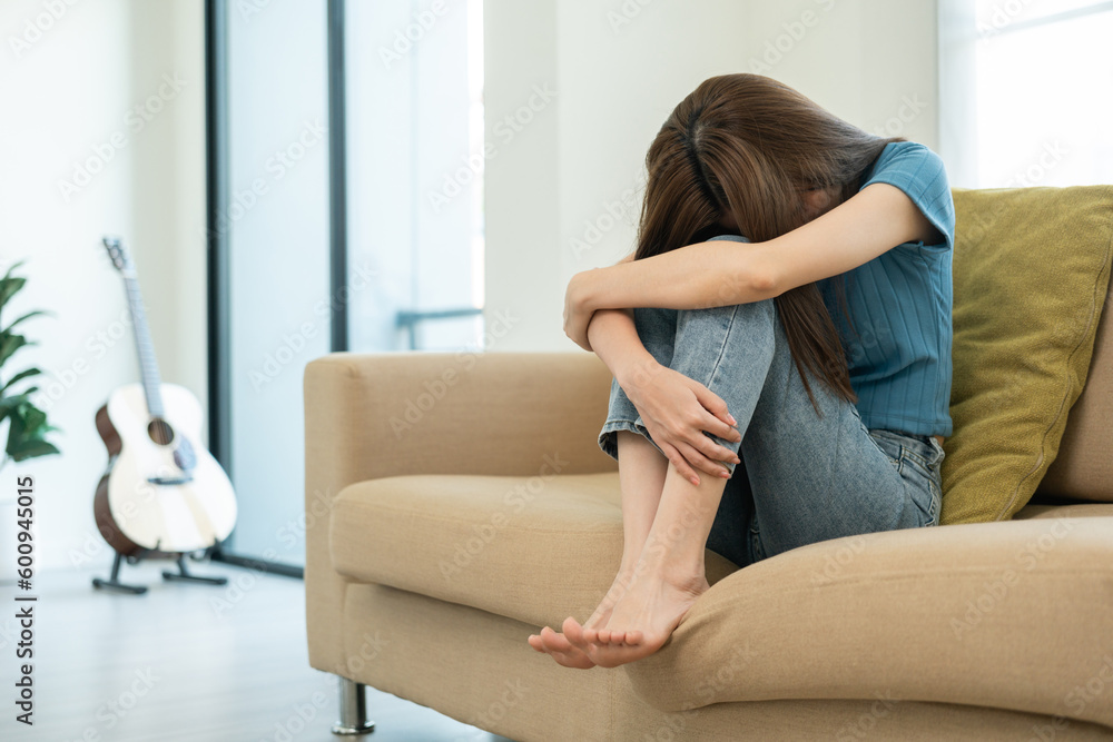 Depressed and Stressed asian woman on sofa. Crying sadness female alone in home problem in life. Unhappy asian woman headache Upset frustrated by problem love relationship feeling despair and anxiety Depressed and Stressed asian woman on sofa. Crying sadness female alone in home problem in life. Unhappy asian woman headache Upset frustrated by problem love relationship feeling despair and anxiety