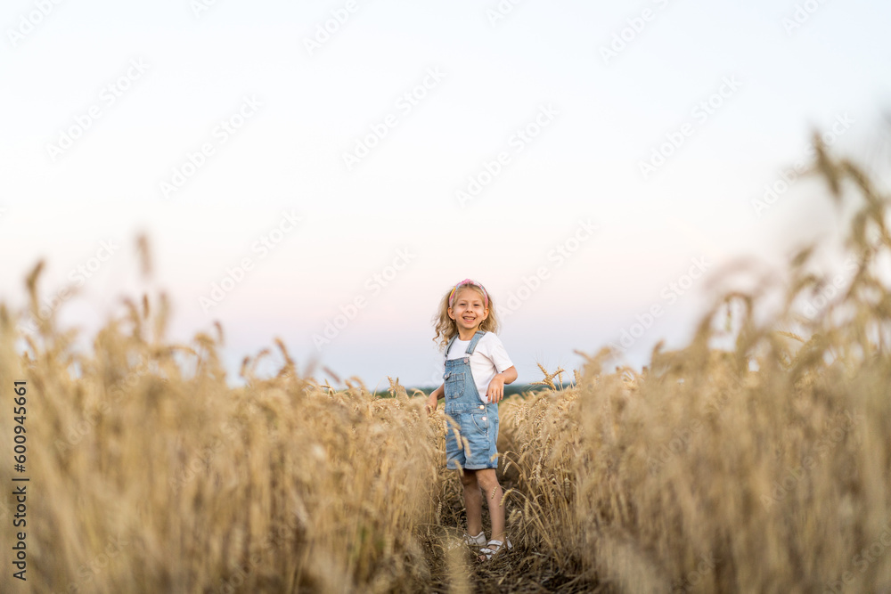 a little blonde curly girl running in a wheat field, the concept of human freedom a little blonde curly girl running in a wheat field, the concept of human freedom