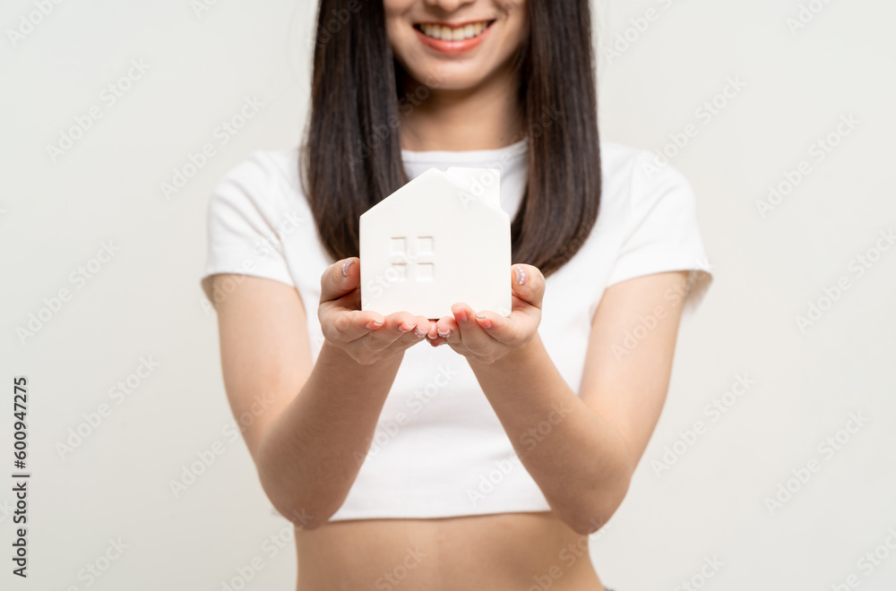Young cute asian woman holding house mock up standing on isolated white background. Real estate and home insurance concept. Business Woman with house sample model. Young cute asian woman holding house mock up standing on isolated white background. Real estate and home insurance concept. Business Woman with house sample model.