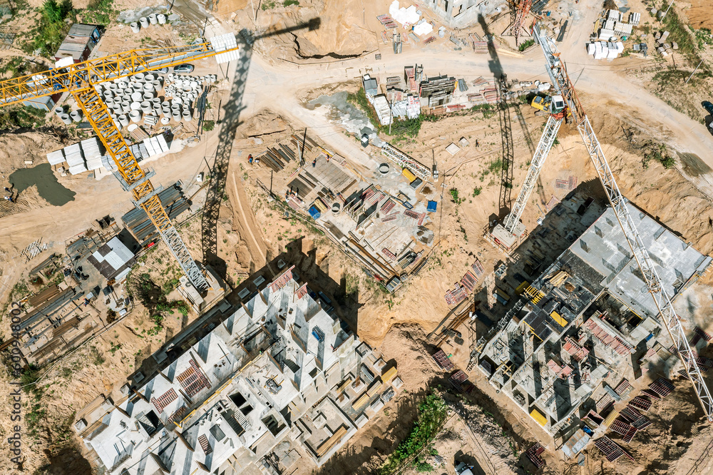 Fototapeta premium new multistory apartment builsings under construction. busy construction site with working cranes. aerial photography with drone.