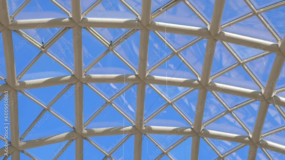 Panorama view of a blue sky through the glass roof of a modern time building with triangular shape of the dome's segments. 4k footage. Panorama view of a blue sky through the glass roof of a modern time building with triangular shape of the dome's segments. 4k footage.