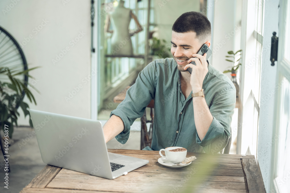 handsome young businessman Working on laptop and working online while sitting at coffee shop table, businessman working outdoors side view handsome young businessman Working on laptop and working online while sitting at coffee shop table, businessman working outdoors side view