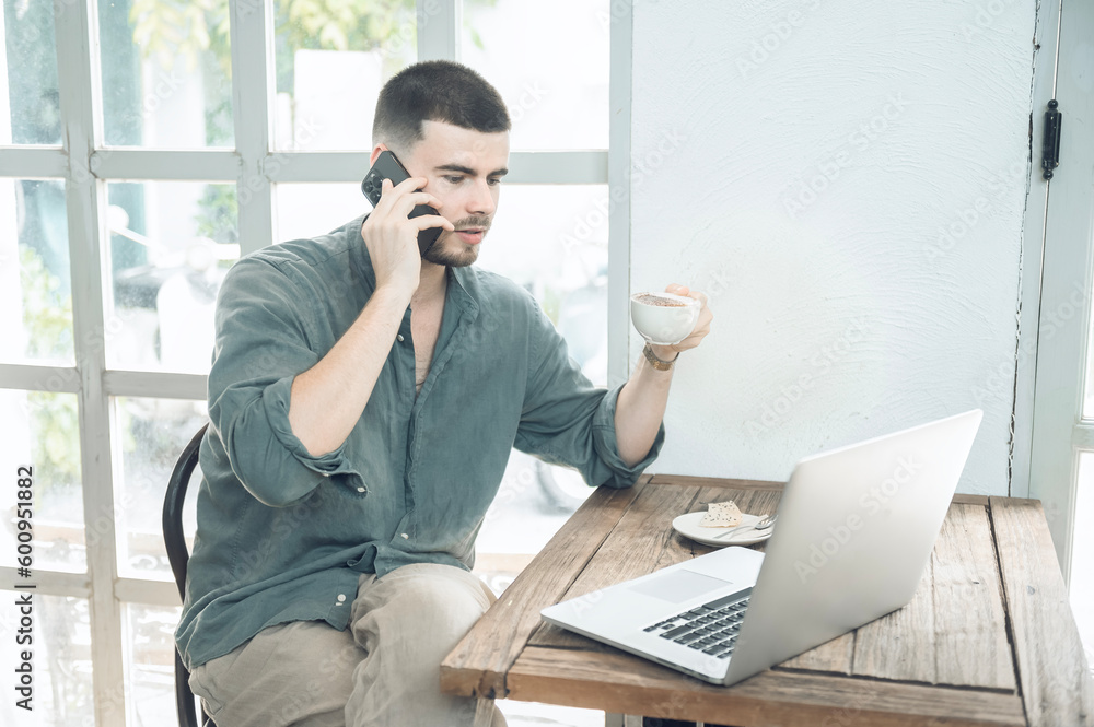 handsome young businessman Working on laptop and working online while sitting at coffee shop table, businessman working outdoors side view handsome young businessman Working on laptop and working online while sitting at coffee shop table, businessman working outdoors side view