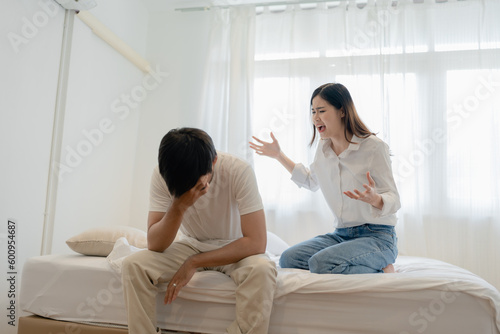 Domestic Violence, Asian Wife Threatening husband, Scared family leader Embracing his While Sitting Together On bed.