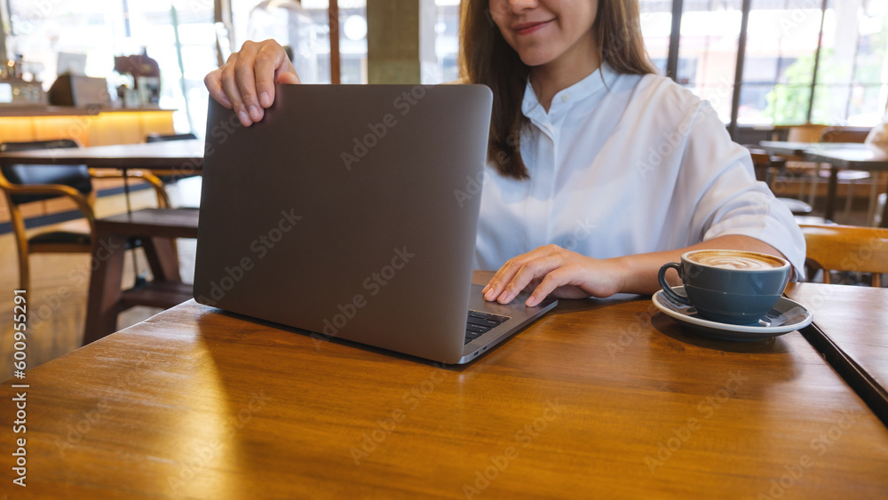 Closeup of a woman opening or closing laptop computer, getting ready for work, finished work in office Closeup of a woman opening or closing laptop computer, getting ready for work, finished work in office