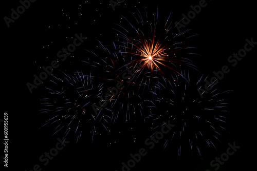 Bright beams of fireworks on black background of night sky. Festive fireworks.