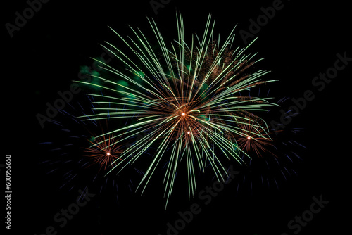 Bright beams of fireworks on black background of night sky. Festive fireworks.