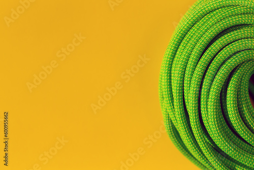 green rope for rock climbing and mountaineering lies on a colored background. background image of rope for active sports.
