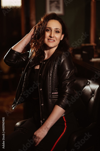 happy beautiful brunette woman posing on chair at bar counter in a pub © alexkoral