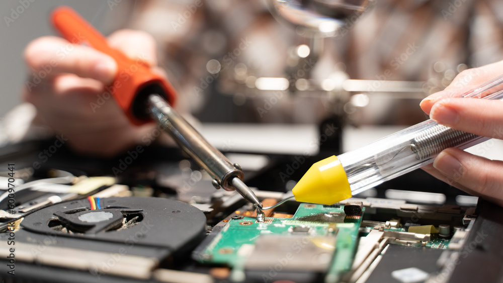 Naklejka premium the master solders the chip, the concept of electronics repair