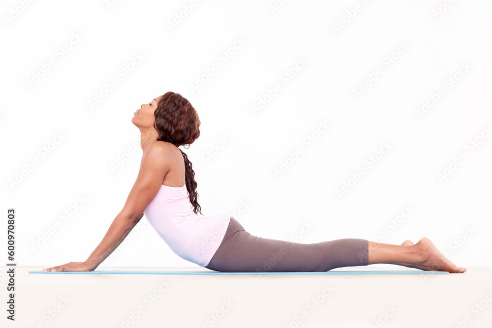 Yoga, cobra back stretch and black woman relax in studio on a fitness and workout mat for training. Isolated, white background and calm African female person lying on the ground with body stretching - obrazy, fototapety, plakaty 