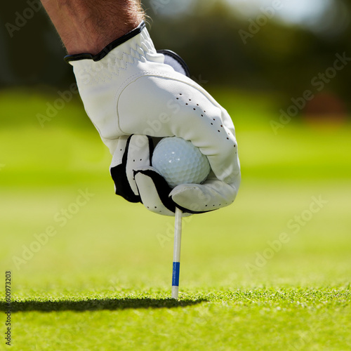 Ball, tee and hands of man on golf course for contest, competition challenge and target training. Closeup, grass lawn and golfer gloves with pin in ground for action, games and sports gear on field