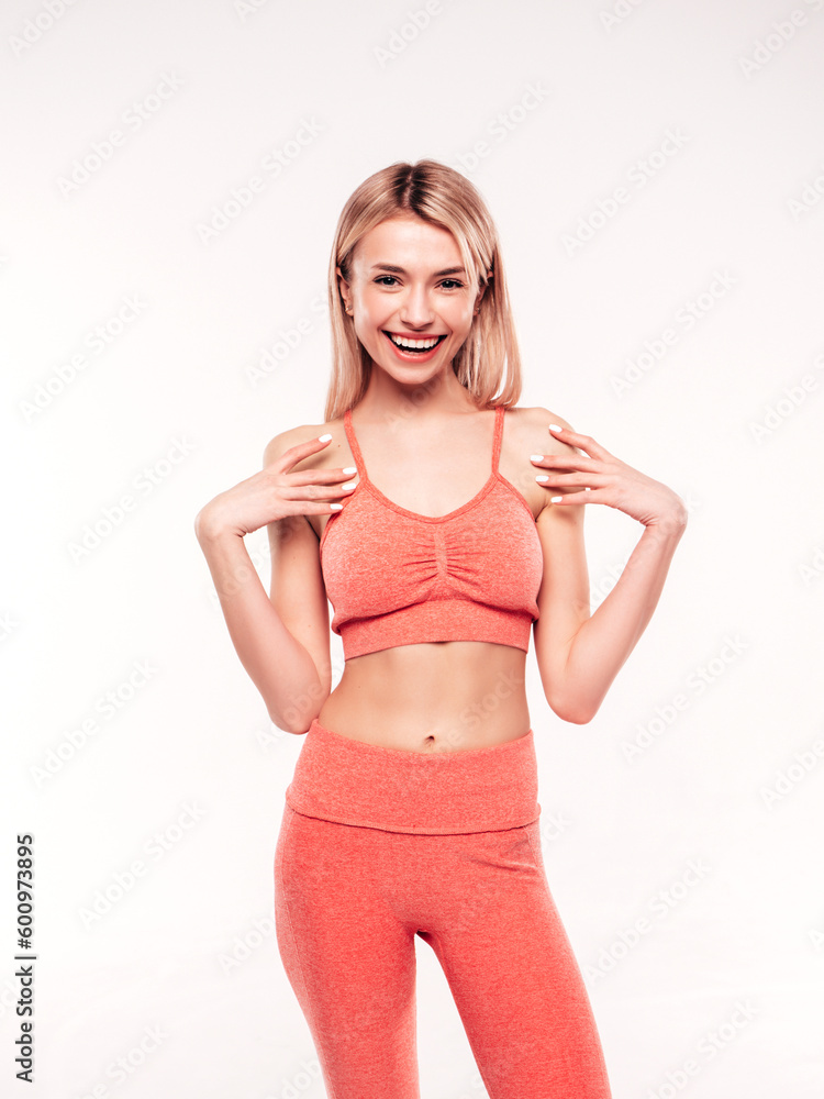 Young beautiful smiling blond female in pink sports clothing costume . Sexy carefree woman posing on white background in studio. Positive model having fun indoors. Cheerful and happy. Very slim Young beautiful smiling blond female in pink sports clothing costume . Sexy carefree woman posing on white background in studio. Positive model having fun indoors. Cheerful and happy. Very slim