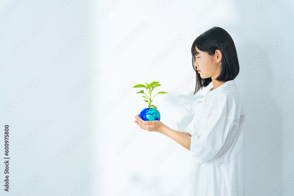 Young Asian girl holding earth drawn plant pot. Environment protection concept. Young Asian girl holding earth drawn plant pot. Environment protection concept.