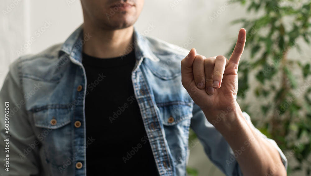 Naklejka premium Sign language interpreter man translating a meeting to ASL, American Sign Language. Empty copy space for Editor's content
