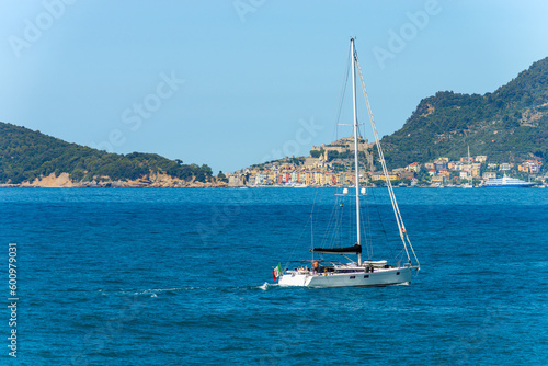 Sailing boat in motion in front of Porto Venere or Portovenere town (UNESCO world heritage site), Gulf of La Spezia, Liguria, Italy, southern Europe.