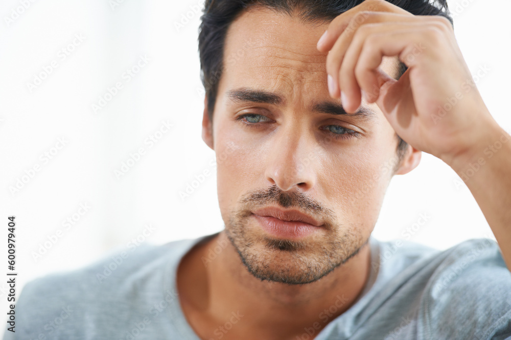 Obraz premium Sad, stress or worried young man on white background in studio with problem. Anxiety face, mental health and stressed out headache for male person thinking or frustrated from depression on backdrop.