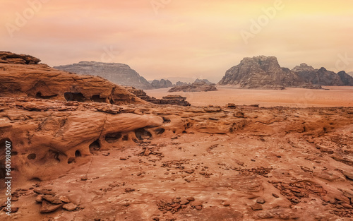 Rocky scenery in Wadi Rum desert during morning, small camp tents visible at distance