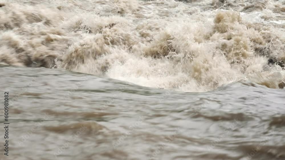 Dirty flood water flowing rapidly in river, closeup abstract detail Dirty flood water flowing rapidly in river, closeup abstract detail