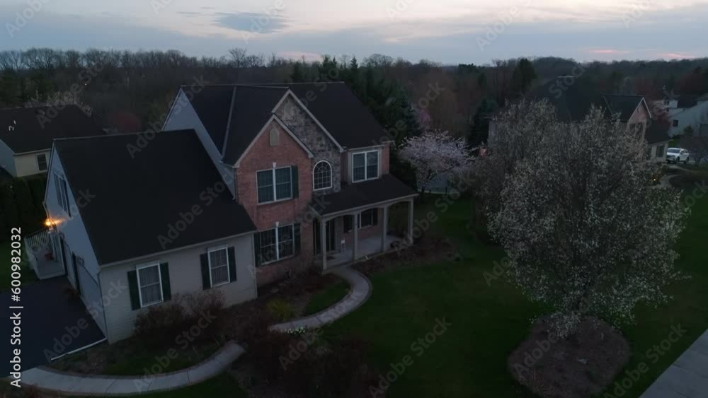 Aerial rising shot of American home at dusk. Tree flowers and blooms in spring. Establishing shot of dark home at night. Aerial rising shot of American home at dusk. Tree flowers and blooms in spring. Establishing shot of dark home at night.