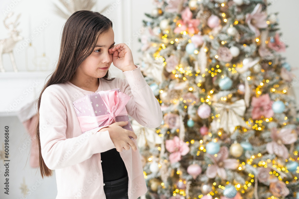 Cute little girl feeling unhappy with her Christmas gifts. living room on Xmas eve. Cute little girl feeling unhappy with her Christmas gifts. living room on Xmas eve.