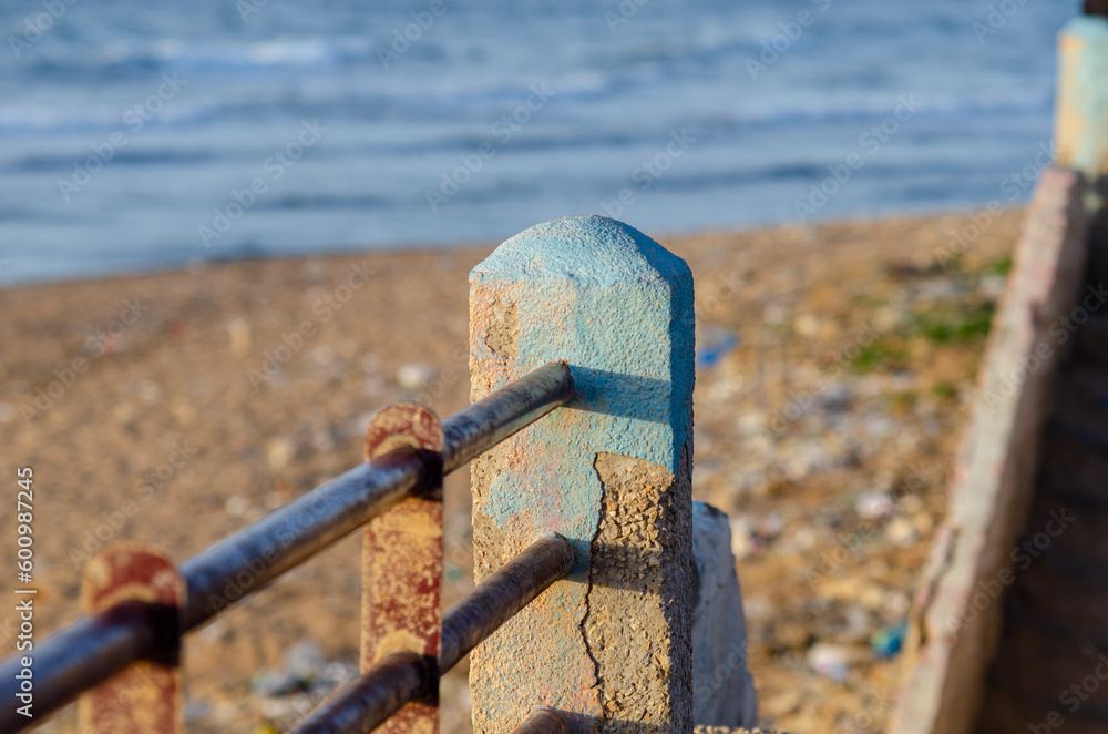 rusty metal fence in front of the sea