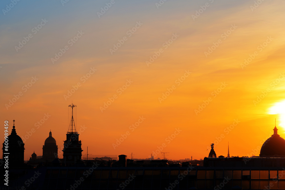Panoramic view of the roofs, towers, domes of churches and cathedrals silhouetted against sunset light on spring evening. Saint-Petersburg, Russia. Travelling and tourism concept. Copy space.