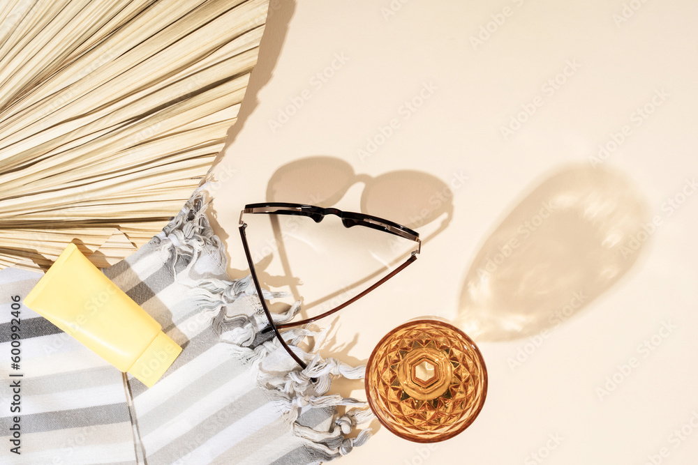 Sunglasses, cream, linen towel, wine and cocktail glass, palm leaf summer beach holiday concept. Sunglasses, cream, linen towel, wine and cocktail glass, palm leaf summer beach holiday concept.