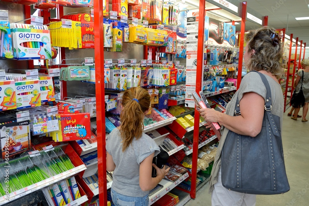 Obraz premium Achat fournitures scolaires. Mère et sa fille devant un rayon