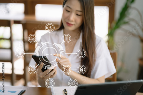 Zero trust security concept Person using smartphone and tablet with zero trust icon on virtual screen of Data businesses.in office.